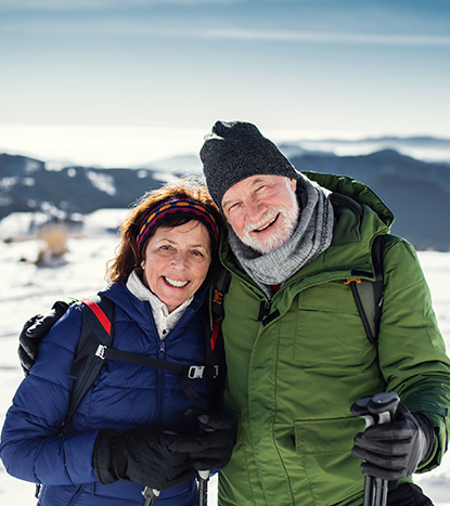 Couple Smiling at Camera Holding Snow Shoe Poles Retirement Planning Tools Michigan