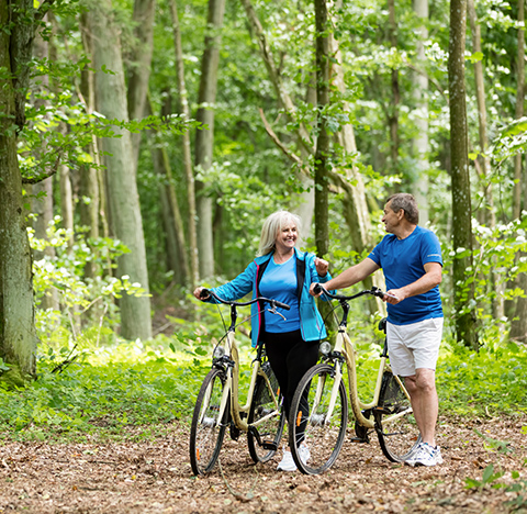 Happy Senior Couple Riding Bikes Through the Woods Guaranteed Basic Income Michigan
