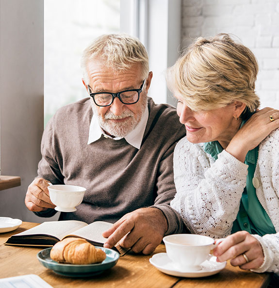 Senior Couple Reading and Eating Breakfast Together Taxes on Retirement Income Michigan