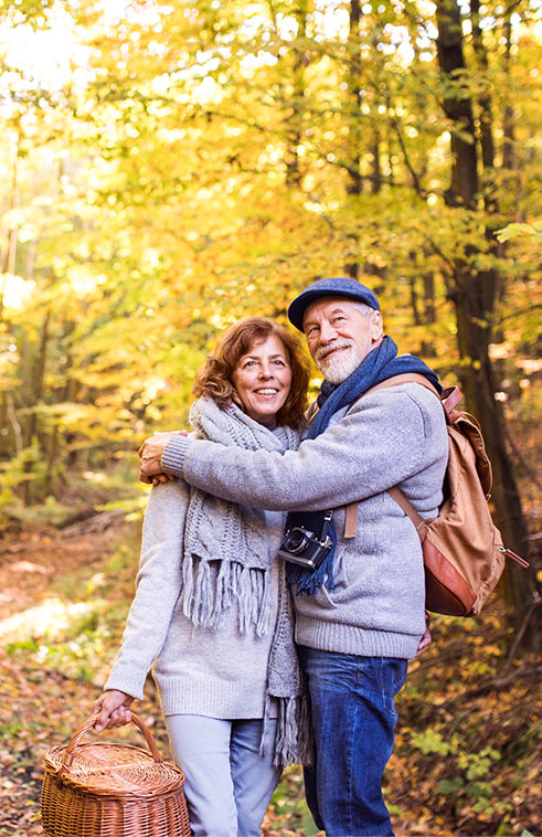 Senior Couple Walking In Woods Holding Picnic Basket Annuity Benefits Michigan